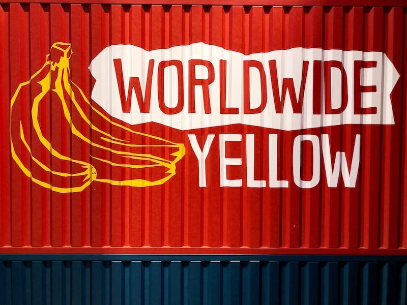 Red shipping container with two big yellow bananas drawn on them